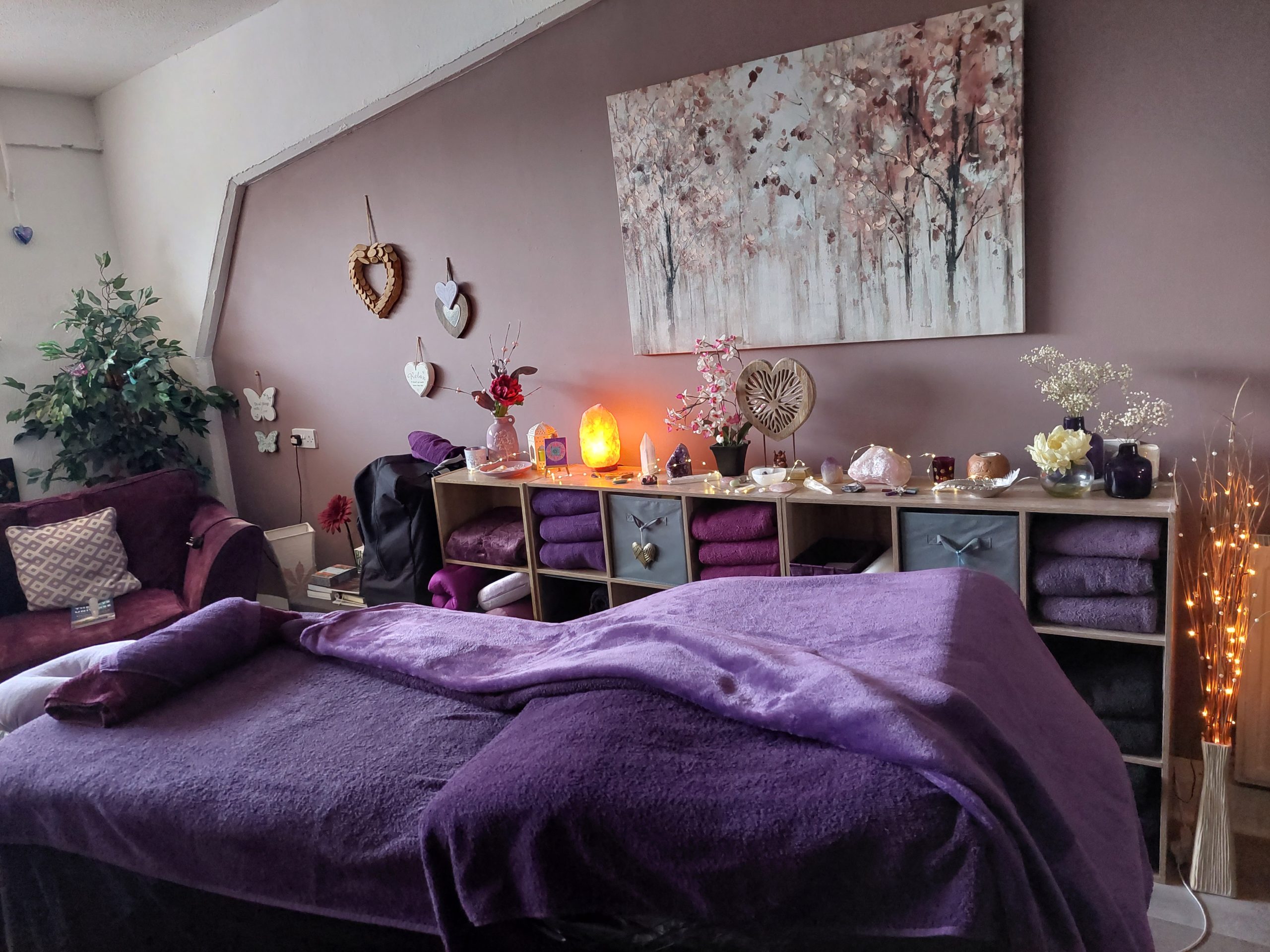 This is a picture of the treatment bed at Libra Light Holistic Therapies in Falkirk. The colour scheme is in relaxing purple tones.